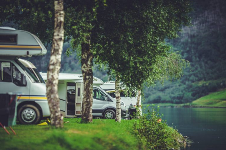 Un grupo de autocaravanas pernoctando junto a un lago.