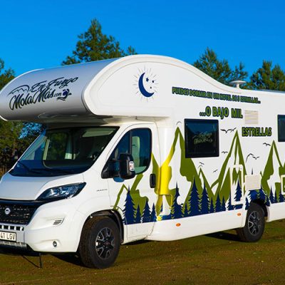 Un rv blanco estacionado en un campo.